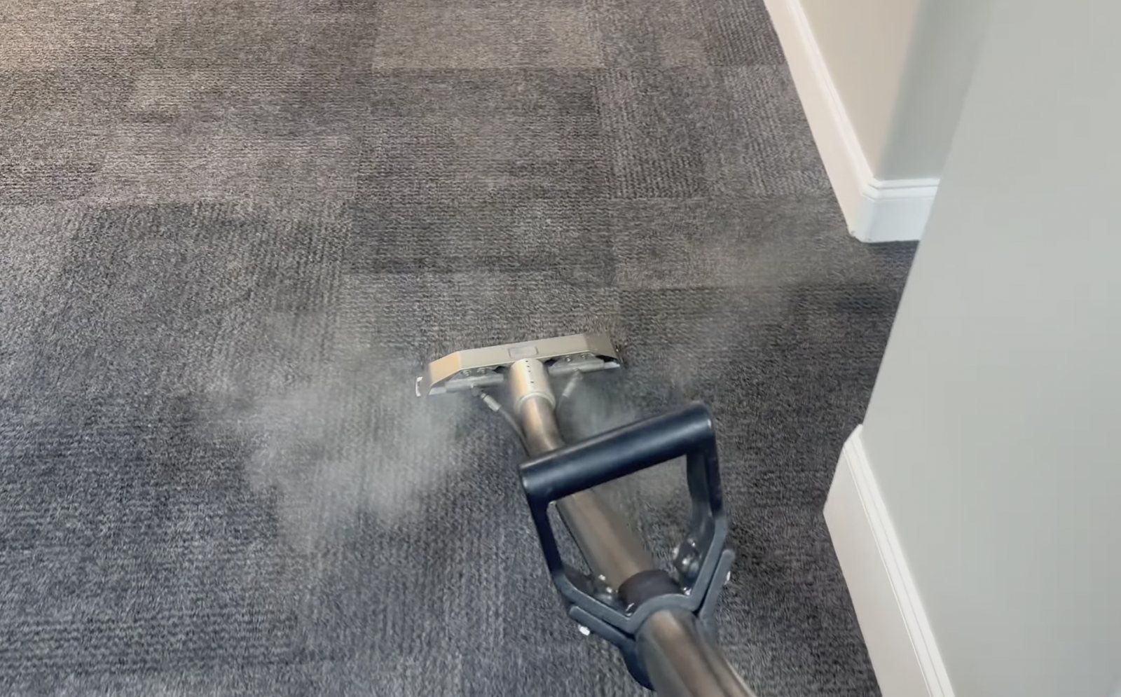 Hot-water extraction carpet cleaning in an Apollo Beach, FL home: cleaning wand rinsing and extracting a gray hallway carpet